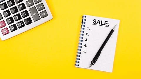 Calculator, pen and notebook with text in red and black font sale on a yell.. Stock Photos