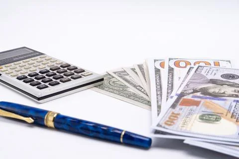 Calculator, Pen, and Stack of Hundred Dollar Bills on White Background, Fin.. Stock Photos