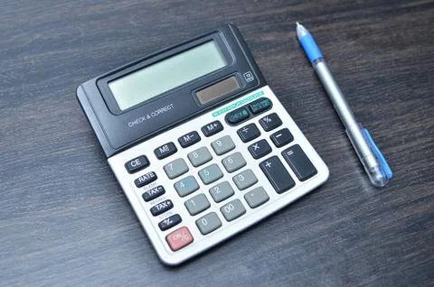 Calculator with pen on wood board background Stock Photos