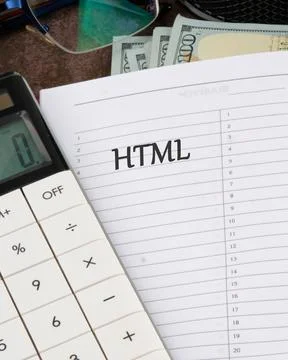 A calculator rests beside a notebook featuring HTML handwritten on its page,  Stock Photos