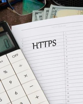 A calculator rests next to a notebook with HTTPS written on the page, all set Foto stock