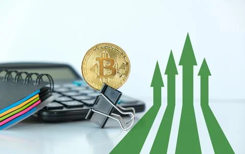 A calculator, a stack of papers, and a clip with a coin on top of it Stock Photos