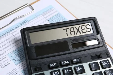 Calculator with word Taxes and document on table, closeup Stock Photos