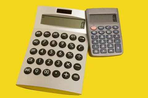 Calculators on a yellow surface Stock Photos