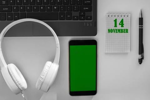 Calendar date on a light background of a desktop and a phone with a green scr Stock Photos