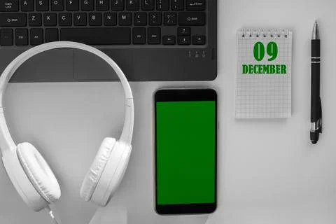 Calendar date on a light background of a desktop and a phone with a green scr Stock Photos