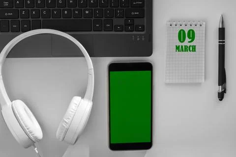 Calendar date on a light background of a desktop and a phone with a green scr Stock Photos