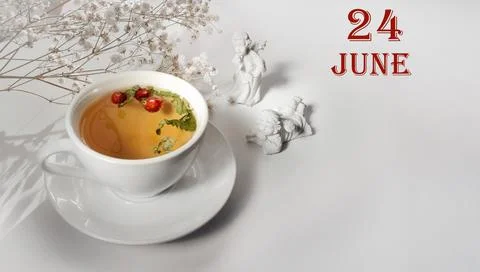 Calendar date on light background with a porcelain cup of green tea, white gy Stock Photos