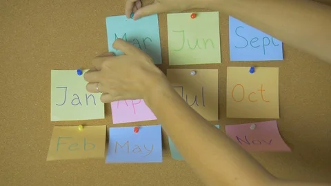 Calendar. Hands pining and taking off sticky windy notes on pin board funny Stock-Footage 99548302