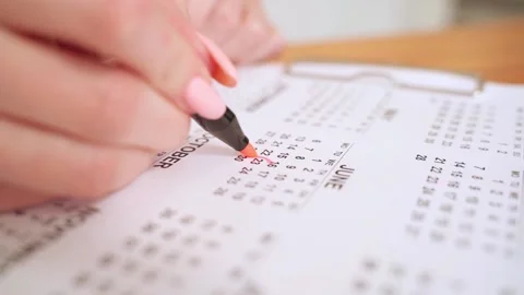 Calendar mark. Hand marking day on calendar with a red marker. Calendar planner Stock Footage 164381642