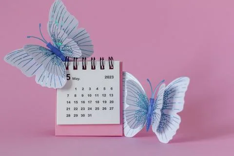 Calendar for May 2023 on a pink background with butterflies. Stock Photos