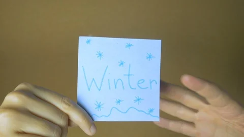 Calendar in motion. Hands passing each other sticky notes with seasons and month Stock Footage 99543718