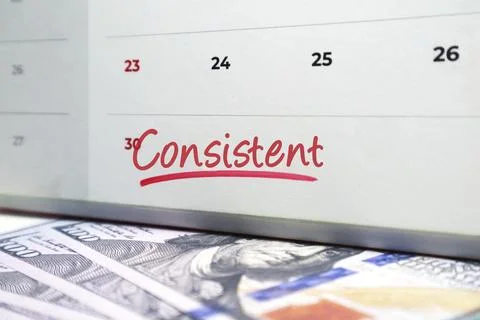 Calendar showing Consistent handwritten in red ink over hundred dollar bill.. Stock Photos