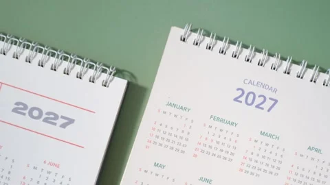 Calendars for 2027 on green background close-up top view. Stock Footage 345019735