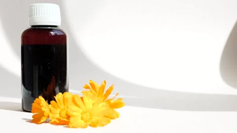 Calendula oil bottle on a white background with copy space. Essential oil . Stock Footage 302286813