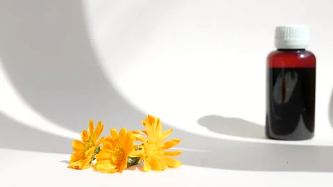 Calendula oil bottle on a white background with copy space. Essential oil . Stock Footage 302287009