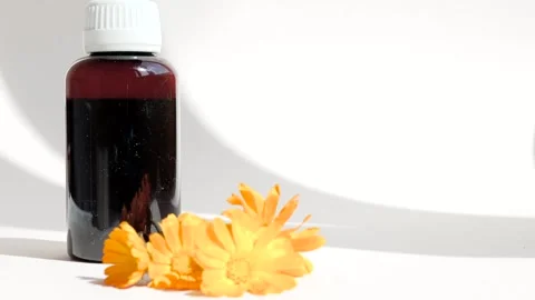 Calendula oil bottle on a white background with copy space. Essential oil . Stock Footage 302287129