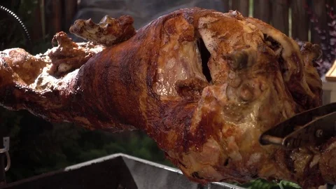 The Calf roasting on a Spit covered with a Crispy golden brown Video stock 76016135