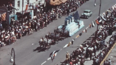 Calgary - 1948: Crowds lining the street watch a parade float pulled by horses Stock Footage 290070867