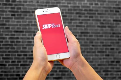 Calgary, Alberta. Canada Dec 4 2019: Woman holds an iphone plus with the Skip Stock Photos