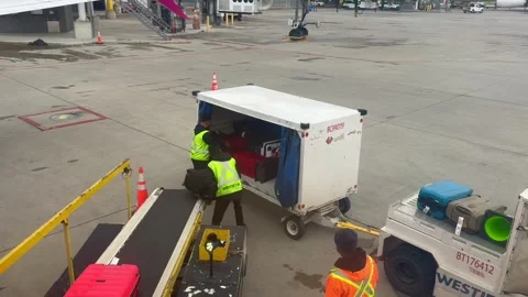 Calgary, Canada - June 11, 2026: Two airport ground crew members in safety vests Stock Footage 341925777