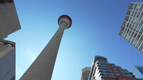 Calgary Tower landmark soaring above surrounding buildings against clear blue Stock Footage 330880282