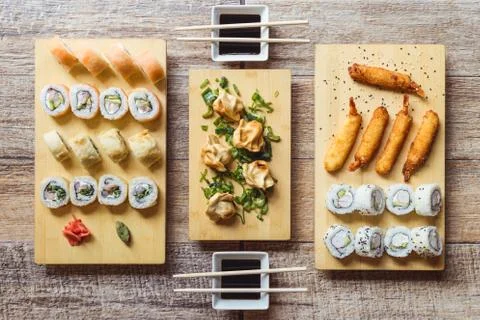 California sushi roll, sake sushi roll, fried shrimps, gyozas and soy sauce o Stock Photos