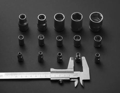 A caliper and a collection of interchangeable socket adapters. Stock Photos