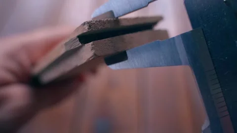 Caliper measures an element of a parquet board close-up Stock Footage 262638824