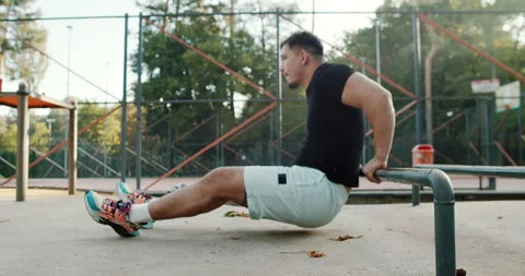 Calisthenics Workout Engaging in Strength Training Utilizing Parallel Bars for Stock Footage 317756568