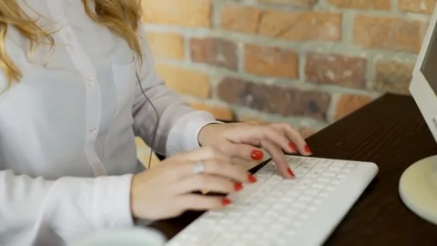 Call center agent talks with client and works on computer, steadycam shot Stock Footage 70419612