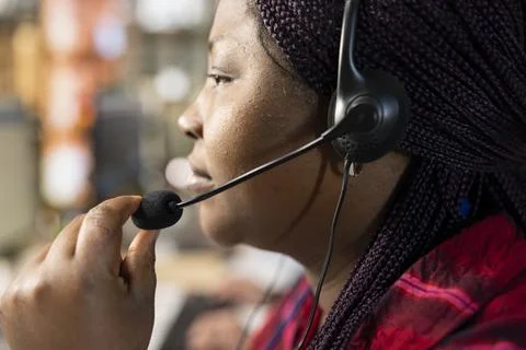 Call center agent using headset mic to answer technical inquiries, close up Stock Photos