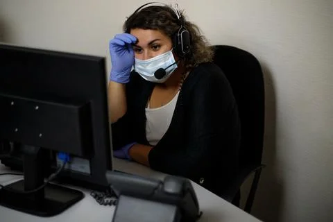 A call center agent working on the support hotline in the office, wearing a m Stock Photos