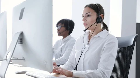 Call Center Agents Consulting Clients On Hotline At Office Stock Footage 99486142