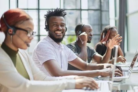 Call center agents smiling happy working at the office. Stock Photos