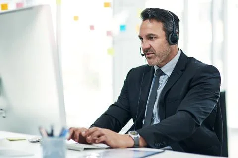 Call center, computer and man in workplace, headset and connection for help.. Fotos de archivo