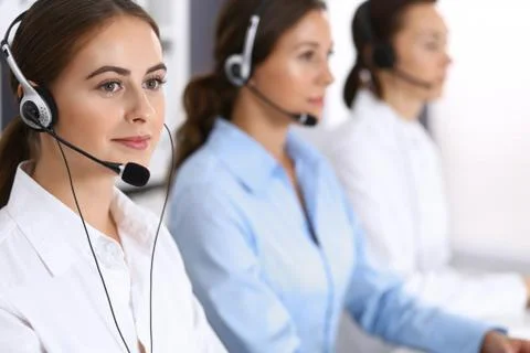 Call center. Group of operators at work. Focus at beautiful business woman in Stockfoto's