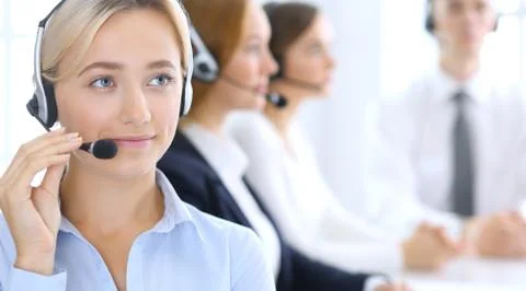 Call center. Group of operators at work. Focus at blonde business woman in Stockfoto's