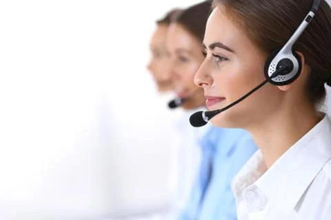 Call center. Group of operators at work. Focus at beautiful business woman in Фото