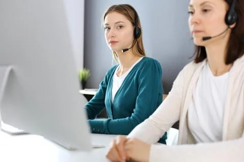 Call center. Group of operators at work. Focus on beautiful woman receptionist Stock Photos