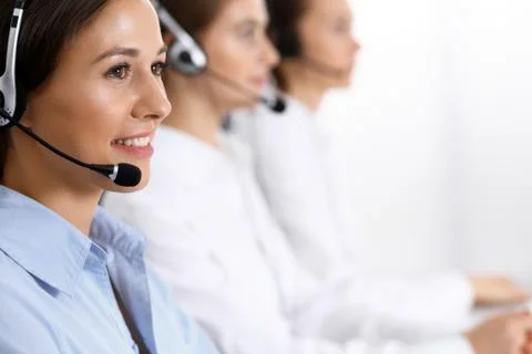 Call center. Group of operators at work. Focus on beautiful business woman in Stock Photos