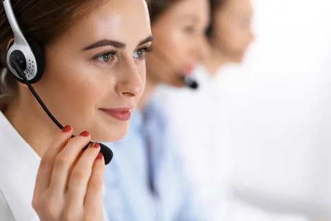 Call center. Group of operators at work. Focus at beautiful business woman in Stockfoto's