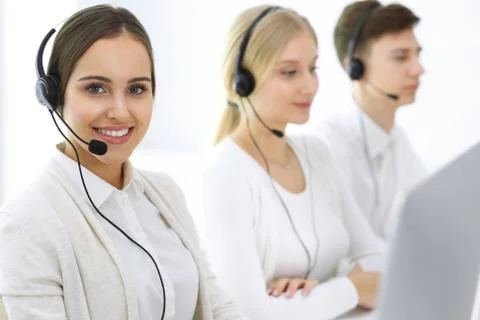Call center. Group of operators at work. Focus on beautiful woman receptionist Stock Photos