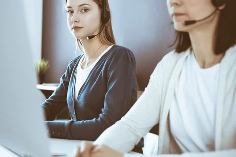Call center. Group of operators at work. Focus on beautiful woman receptionist Stock Photos
