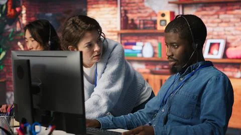 Call center manager teaching intern how to track clients shipment parcels 库存照片