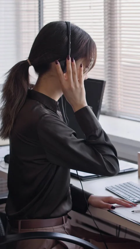 Call Center Operator Consulting Customers via Headset with Microphone 스톡 동영상 335748793