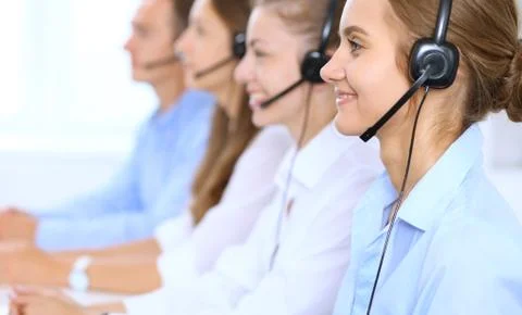 Call center operator in headset while consulting client. Telemarketing or phone Stockfoto's
