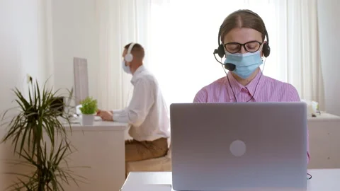 Call center operators in protective masks and headsets work  Stock Footage 162221626