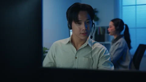 Call center team customer support service work support in night office. Stockbeeldmateriaal 333942722