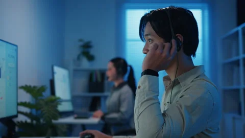 Call center team customer support service work support in night office. Stockbeeldmateriaal 333942810